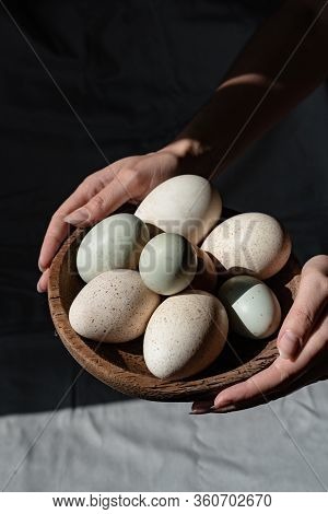 Araucana Eggs And Goose Eggs On A Wooden Plate