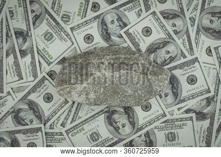 Stone On A Group Of Money Stack Of 100 Us Dollars Banknotes A Lot Of The Background, Top View