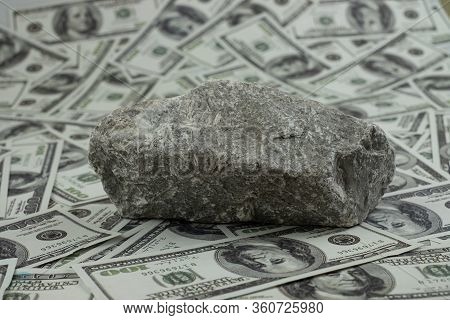 Stone On A Group Of Money Stack Of 100 Us Dollars Banknotes A Lot Of The Background