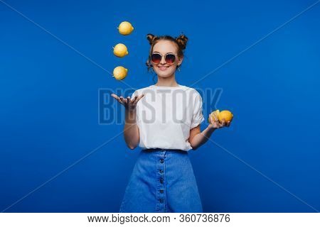 Beautiful Bright Girl In Retro Style, Throws Up Yellow Lemons. Happy Girl