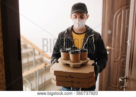 First Persom View Of Delivery Man In Mask And Gloves Give Pizza And Coffe. Stay Home