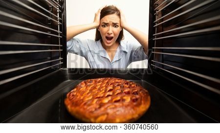 Shocked Housewife Checking Her Oven, Looking At Burnt Pie, View From Inside