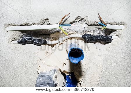 Cut Single-phase Cable In The Wall Of The House. Phase, Neutral And Ground Wire Visible.