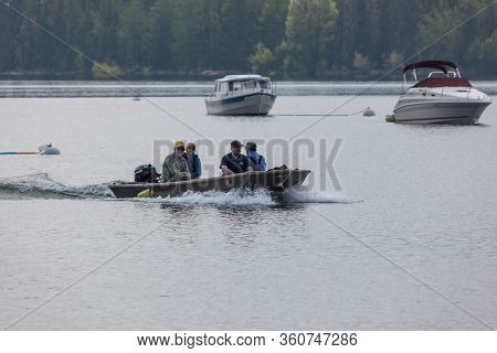 Grand Teton National Park, Wyoming / Usa - July 17, 2014:  Four Men In A Small Boat Coming Into Colt