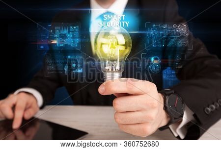 Businessman holding lightbulb with SMART SECURITY inscription, online security idea concept