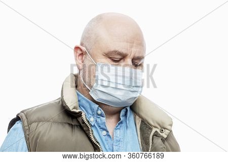 Bald Adult Man In A Medical Mask On A White Background. Close-up. Precautions Quarantined For The Pe