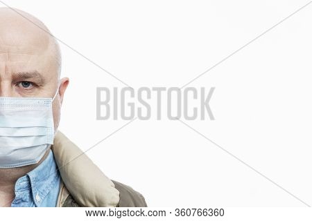 Bald Adult Man In A Medical Mask On A White Background. Close-up. Precautions Quarantined For The Pe