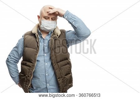 Sad Bald Adult Man In A Medical Mask Stands Holding His Head With His Hand. Precautions Quarantined 