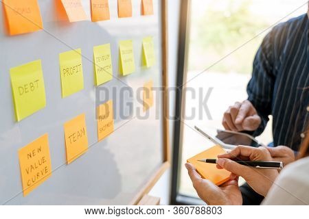 Young Business Workers Posting With Sticky Notes Stickers Reminders  Creative Brainstorming At Board