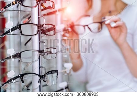 Row Of Glasses At An Opticians. Eyeglasses Shop. Stand With Glasses In The Store Of Optics. Woman Ch
