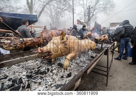 Kacarevo, Serbia - February 18, 2017: Man Roasting A Pig And A Lamb, On A Traditional Grill Of Serbi
