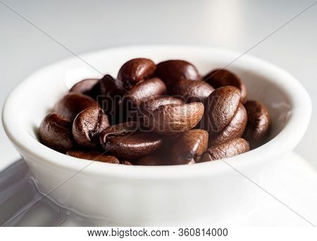 Coffee Beans And A White Cup On The Kitchen Table