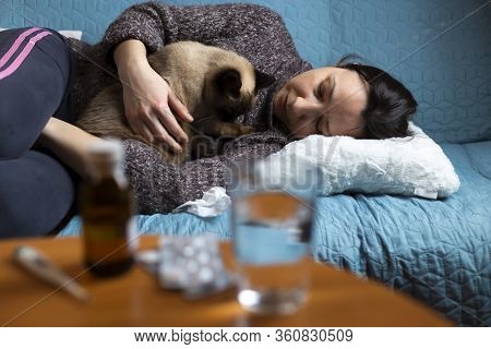 Woman Feeling Sick And Have Cramps Lying On Sofa And Have Some Medicamentation On Table