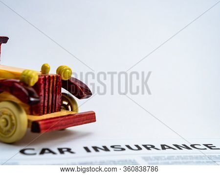 A Vintage Car Toy With Insurance Document On The Ground, Shot On White Background With Copy Space