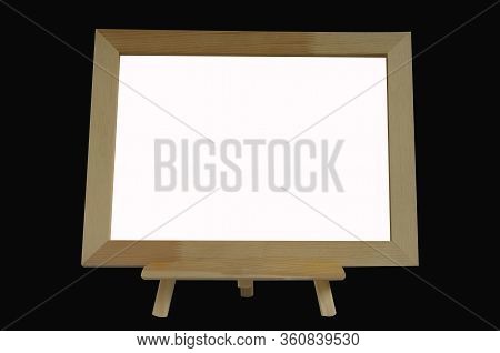 Desktop Wooden Easel And White Blank Canvas In Frame. Isolated Objects On A Black Background. Templa