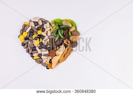 Top View Shot Of A Heart Made Of Ayurvedic Medicines With Herbs And Spices On White Background. Herb