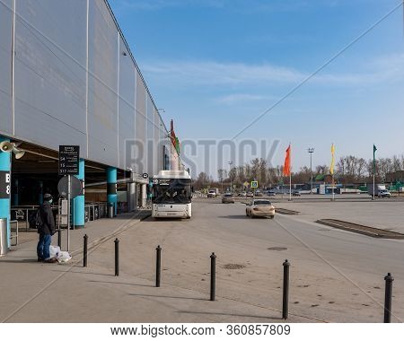 Novosibirsk, Russia-april 12, 2020. A Lone Man In A Medical Mask Stands With Grocery Bags At The Auc