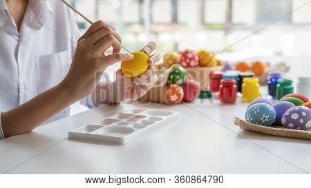Happy Asian Woman Painting Eggs For Eastertime At Home. Family Preparing For Easter.