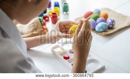 Happy Asian Woman Painting Eggs For Eastertime At Home. Family Preparing For Easter.