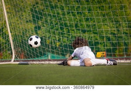 Junior Soccer Goalkeeper. Disappointed Boy In White Goalie Sportswear. Goalkeeper Missed A Goal Duri