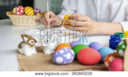Happy Asian Woman Painting Eggs For Eastertime At Home. Family Preparing For Easter.