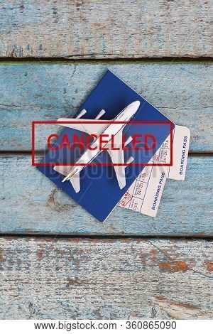 Airplane, Passport And Tickets With A Stamp In Red Text Canceled On A Blue Wooden Background. Flight