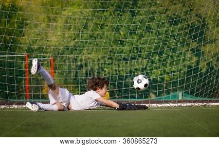 Junior Soccer Goalkeeper. Disappointed Boy In White Goalie Sportswear. Goalkeeper Missed A Goal Duri