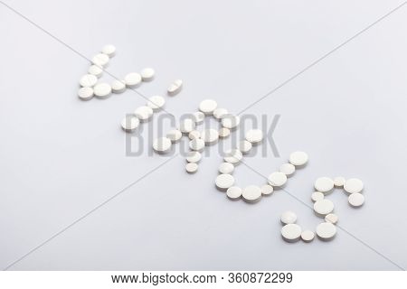Virus Inscription Made Of Round White Pills On A White Background, Medical Concept On The Theme Of T