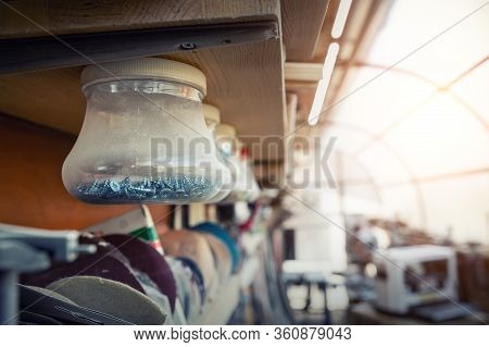 Woodwork Workshop Interior With Many Different Tools And Equipment. Plastic Jars With Many Different