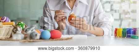 Happy Asian Woman Painting Eggs For Eastertime At Home. Family Preparing For Easter.