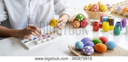 Happy Asian Woman Painting Eggs For Eastertime At Home. Family Preparing For Easter.