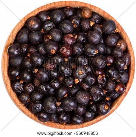 Dried Juniper Berries In A Small Wooden Bow Isolated.