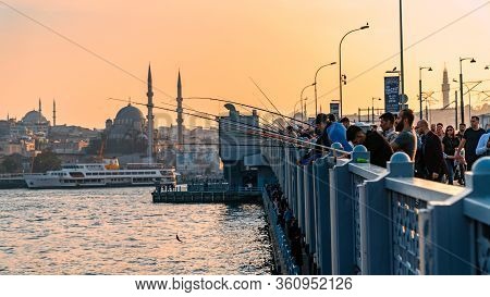 Galata Bridge, Istanbul, Turkey - October 2019: Fishermen On Galata Bridge, Fishing With Their Fishi