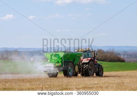 Skutc, Czech Republic - March 23 2020: Tractor Spreading Fertilizer On Grass Field. Agricultural Wor