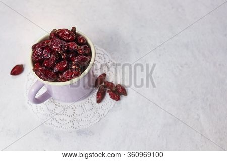 Dried Rose Hips In Enameled Mug Top View On White Background