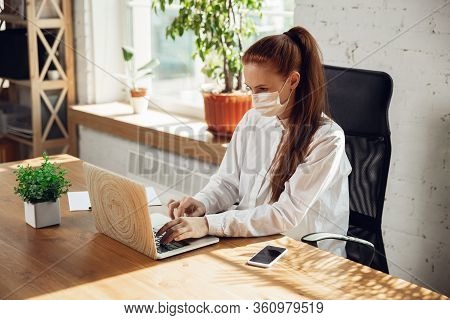 Getting Info. Woman Working In Office Alone During Coronavirus Or Covid-19 Quarantine, Wearing Face 