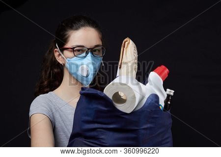 Young Woman In A Valve Of The Respiratory Protective Mask With A Bag Full Of Groceries From The Supe
