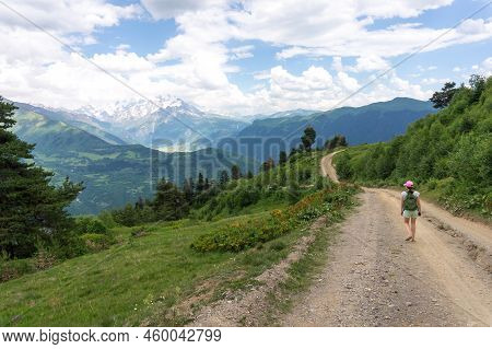 Svaneti Landscape. Young Tourist Single Traveler Woman Walking With A Backpack. Beautiful Caucasus M
