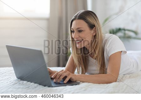 Happy Blonde Woman Using Laptop In Bed, Copy Space