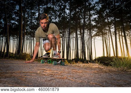 Surf Skater Rolling By The Pine Forest At Sunset