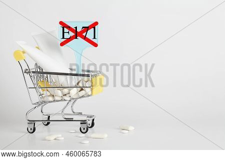 Titanium Dioxide, E171, Dangerous Additive Concept. Gum, Pills, Toothpaste, Cream In Basket And Sign