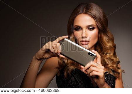 Beautiful Woman Handling Phon. Bright Makeup And Beautiful Hairstyle