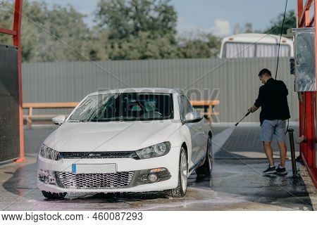 Man Is Wiping The Car With A Microfiber Cloth. Contactless Self-service Car Wash. Personal Car Care 