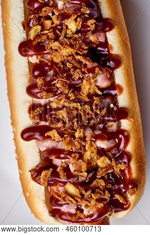 Hotdog With Barbecue Sauce And Bacon On A White Plate On A White Background