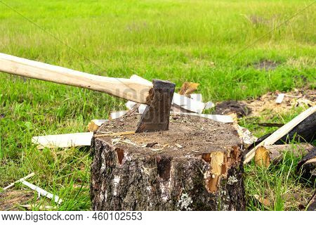 The Wood Chopper Sticks Out In Wooden Hemp. Ax And Ax Handle. Man's , Male Hands In White Colors Glo