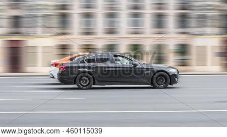 Car Bmw 5 Series On The Road In Motion. Fast Speed Drive On City Road. Side View Of Moving Black Aut