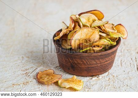 Dried Sliced Apples In A Brown Bowl On A Light Concrete Background. Natural Fruit Chips. Healthy Foo