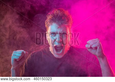 Shouting Angry Young Man With Bright Emotions Isolated Over Pink Background With Smoke. Concept Of M