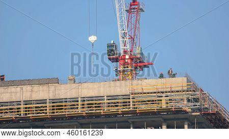 Kyiv, Ukraine - 24.04.2019: Building Construction With Scafolding And Red Crane. Working Men On The 