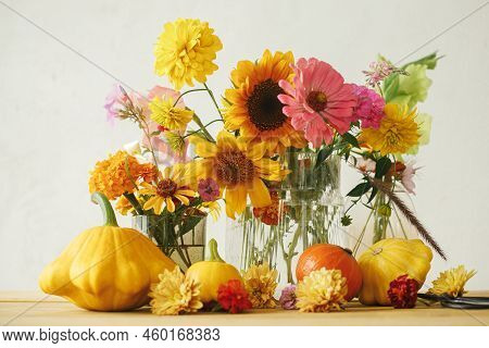 Stylish Autumn Composition On Rustic Table. Colorful Autumn Flowers, Pumpkins, Pattypan Squashes On 